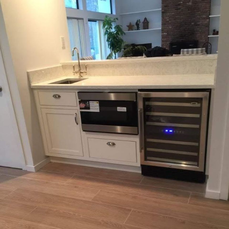 Basement wet bar with quartz counter and wine fridge by general contractor in Suffolk County NY