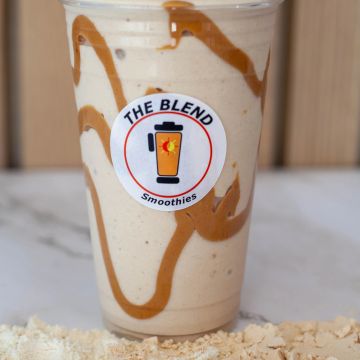 Creamy smoothie with caramel drizzle in a branded clear cup