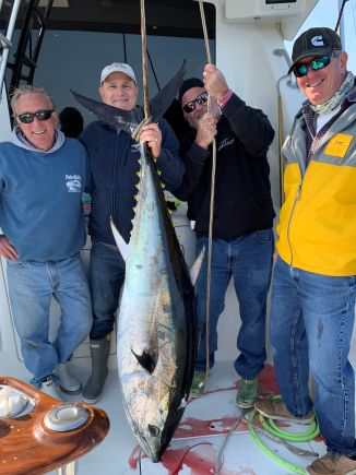 4 men large bluefin tuna hanging on boat