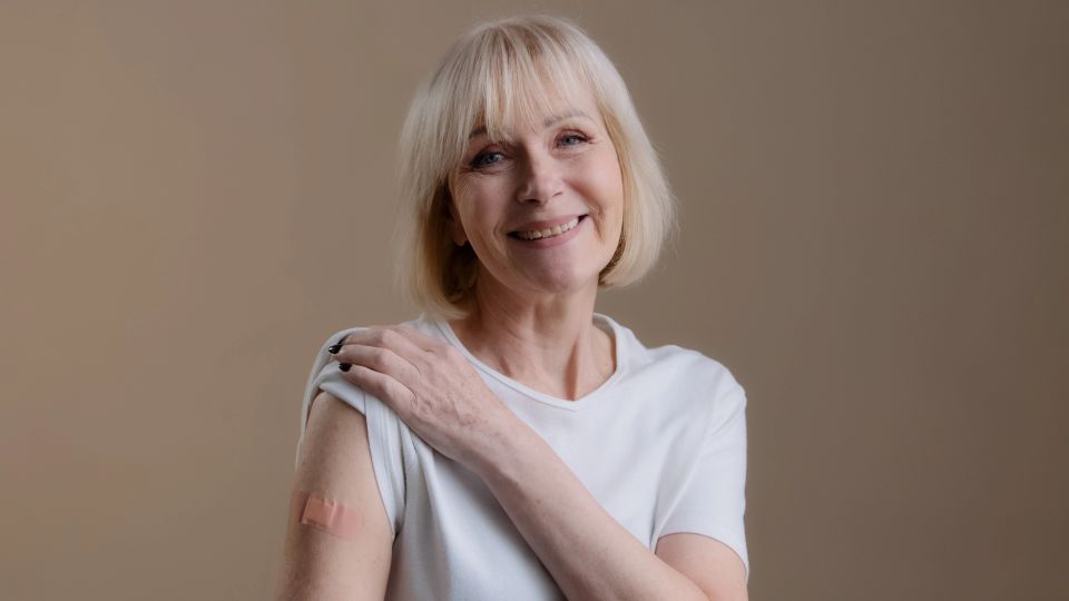 Senior woman smiling after receiving a vaccine