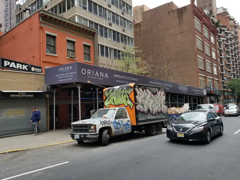 Printed banner running the full length of a sidewalk shed on a Manhattan block