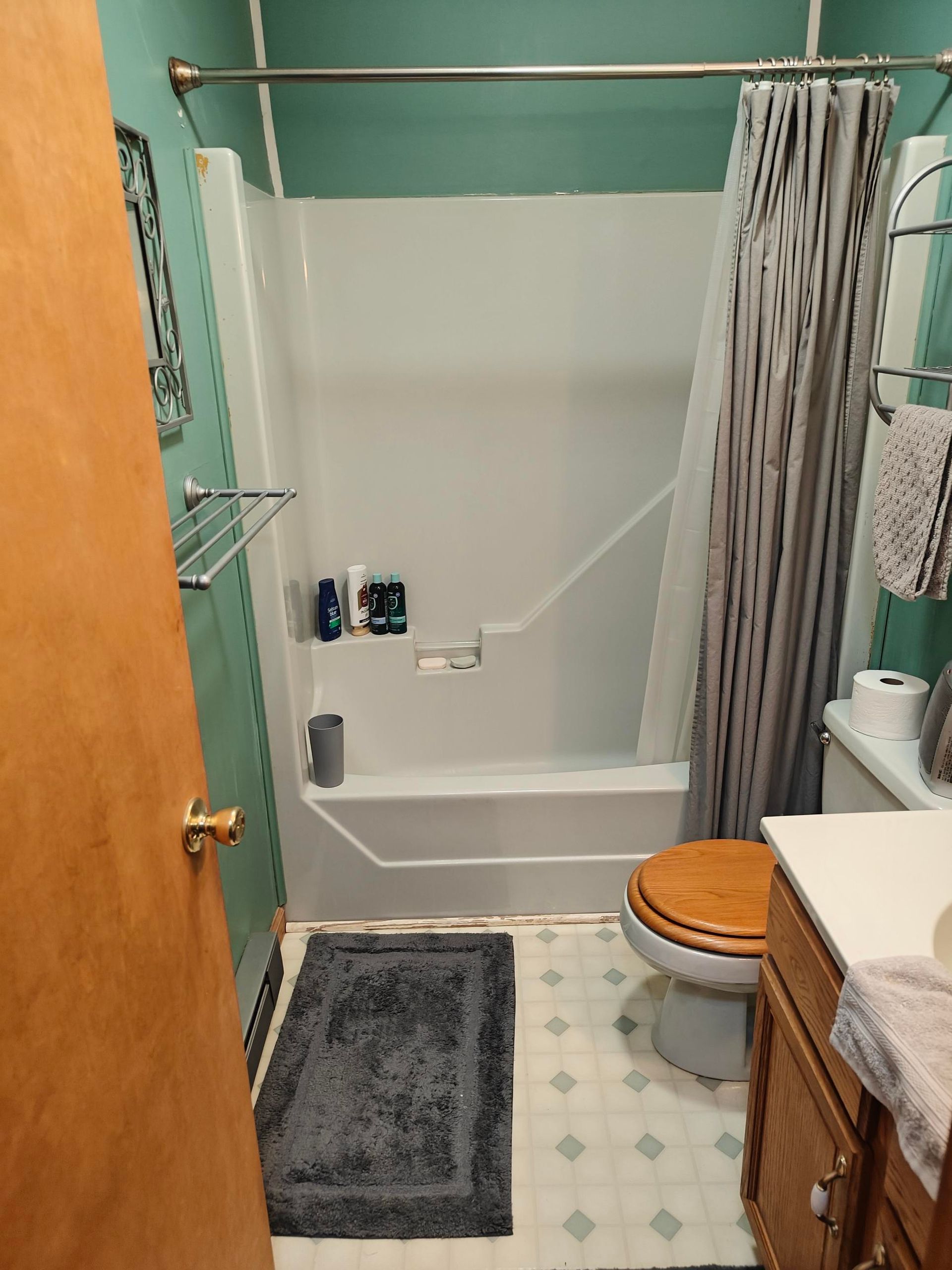 Old fiberglass tub with worn, water-damaged trim at the base