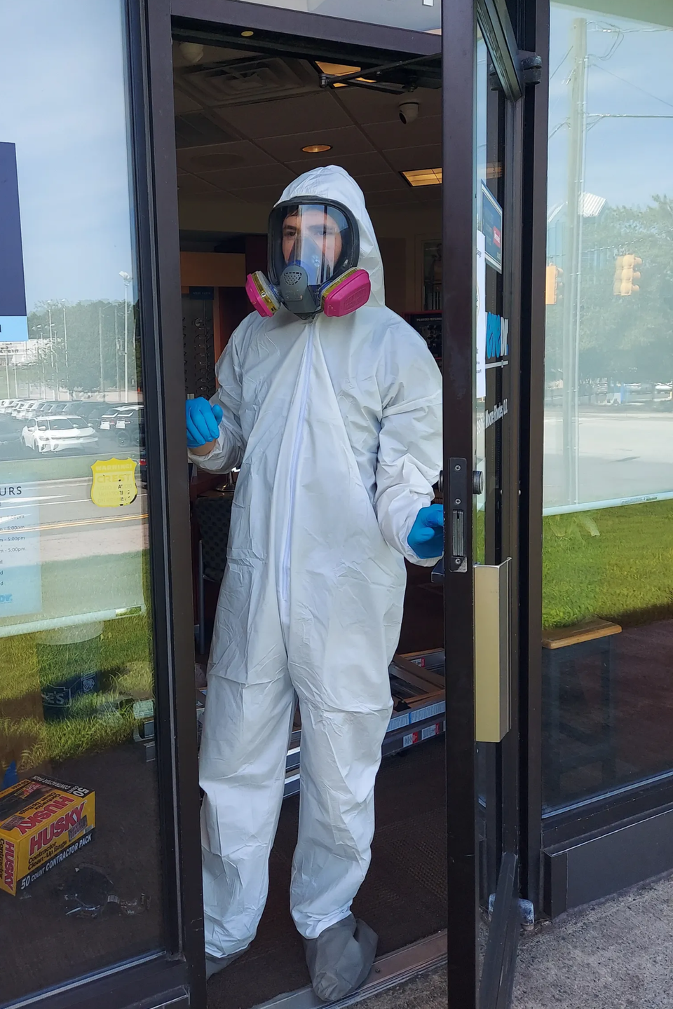 photo of man dressed in hazmat performing commercial restoration service commercial restoration company, natural restoration