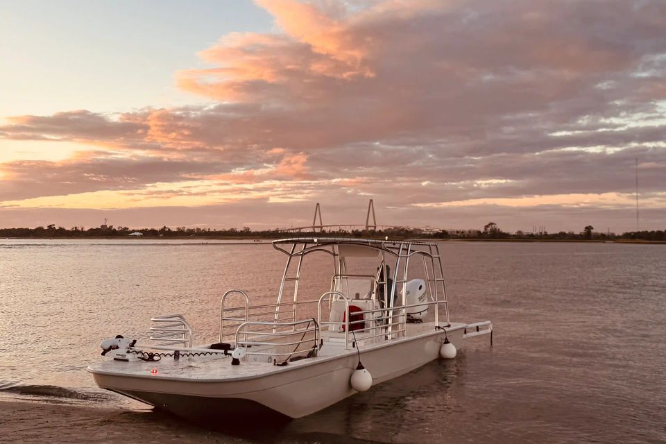 27-foot skiff anchored in Charleston Harbor during a colorful sunset with the Ravenel Bridge in the distance