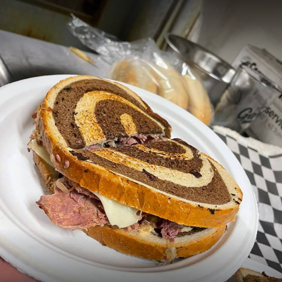 Sandwich on marble bread served on a plate in a kitchen setting