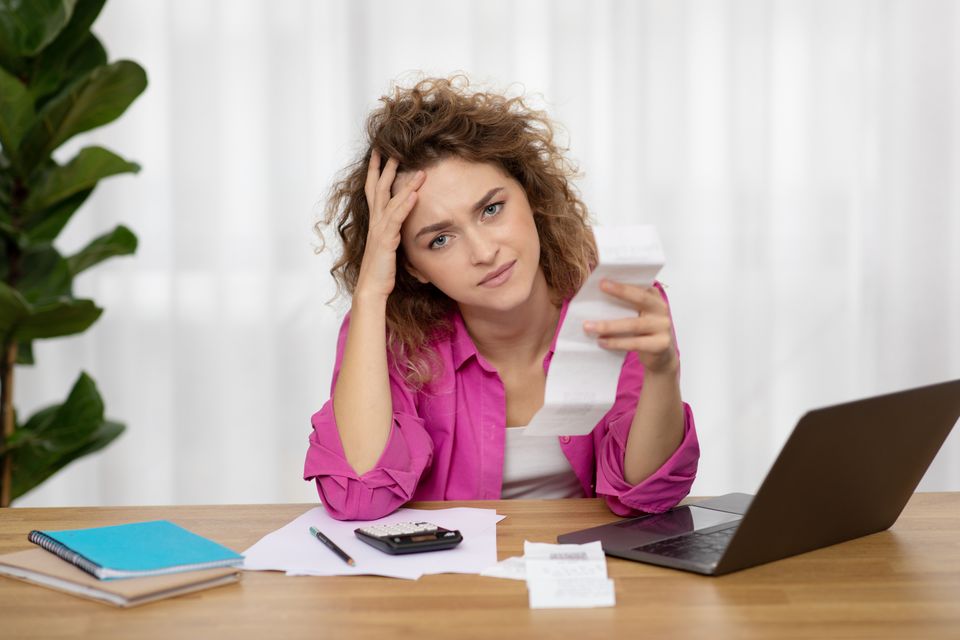 Stressed young female checking bills while sitting 2023 11 27 04 54 09 utc