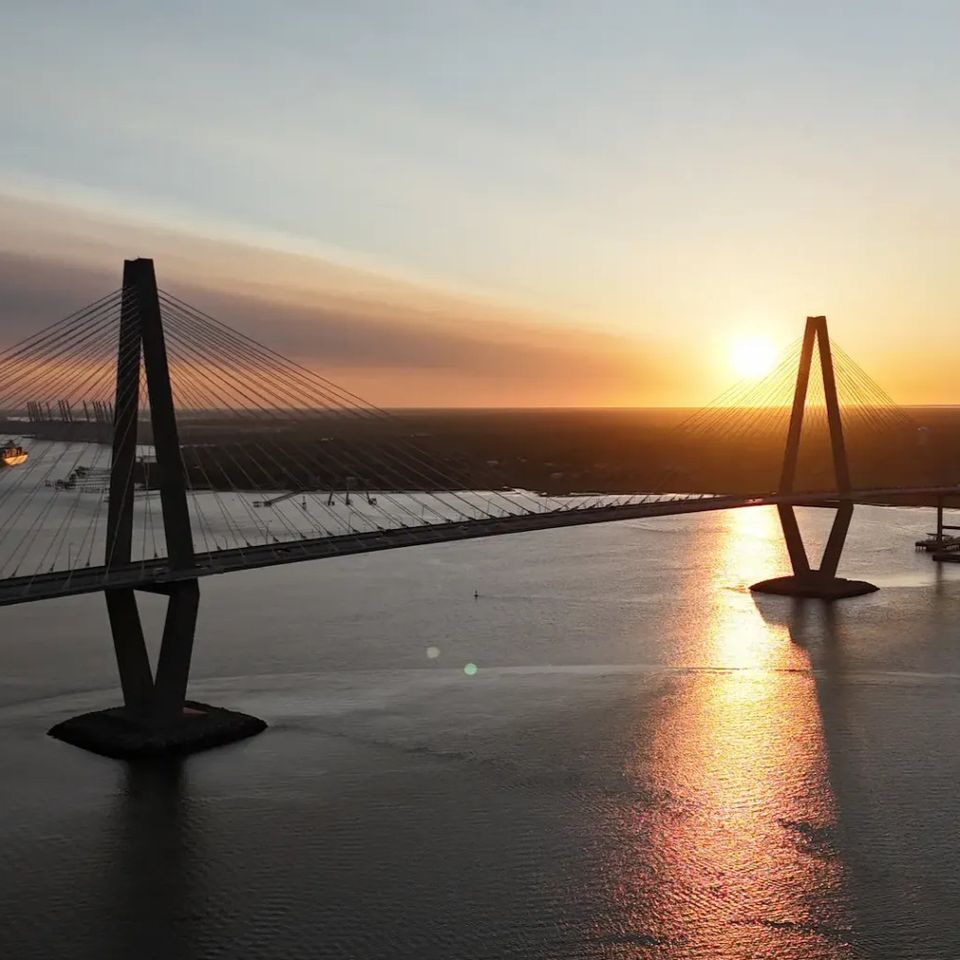 Sunrise view of the Ravenel Bridge and Charleston Harbor from the water during a LowCountry Coastal Excursions boat tour.
