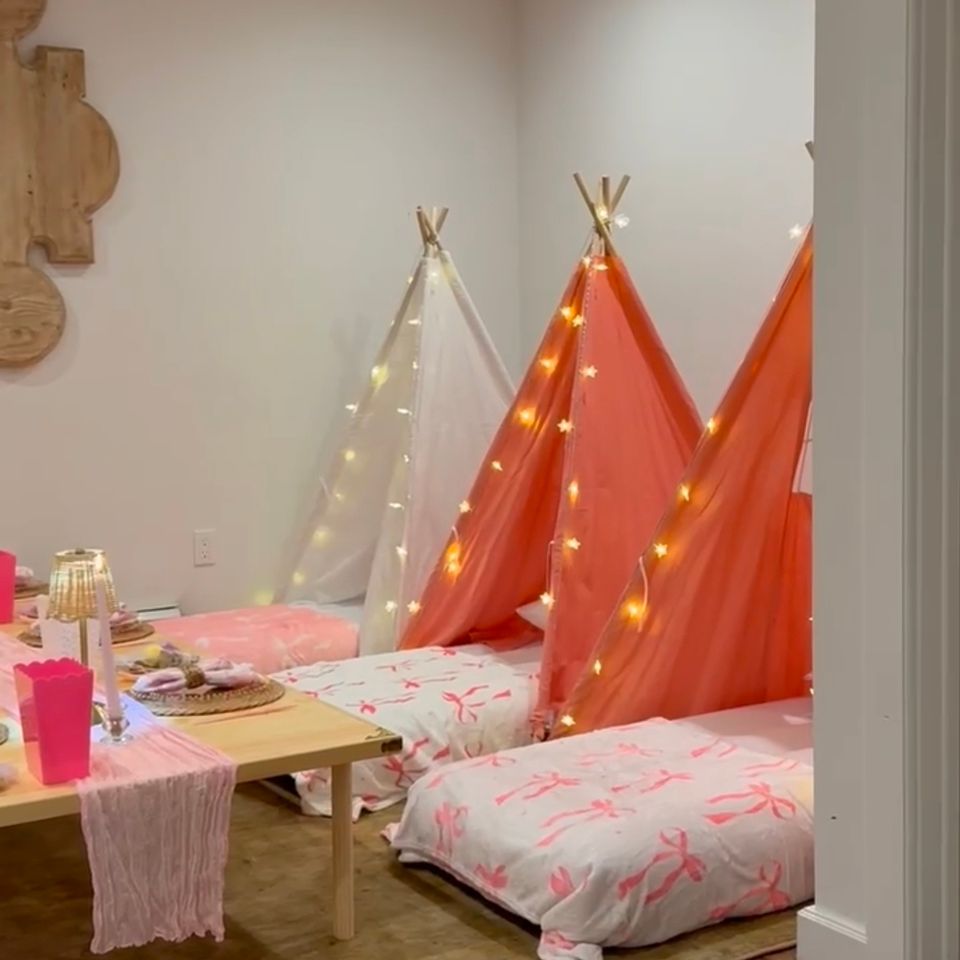 Indoor sleepover party setup with lighted teepee tents and a low styled table in a Hamptons NY home