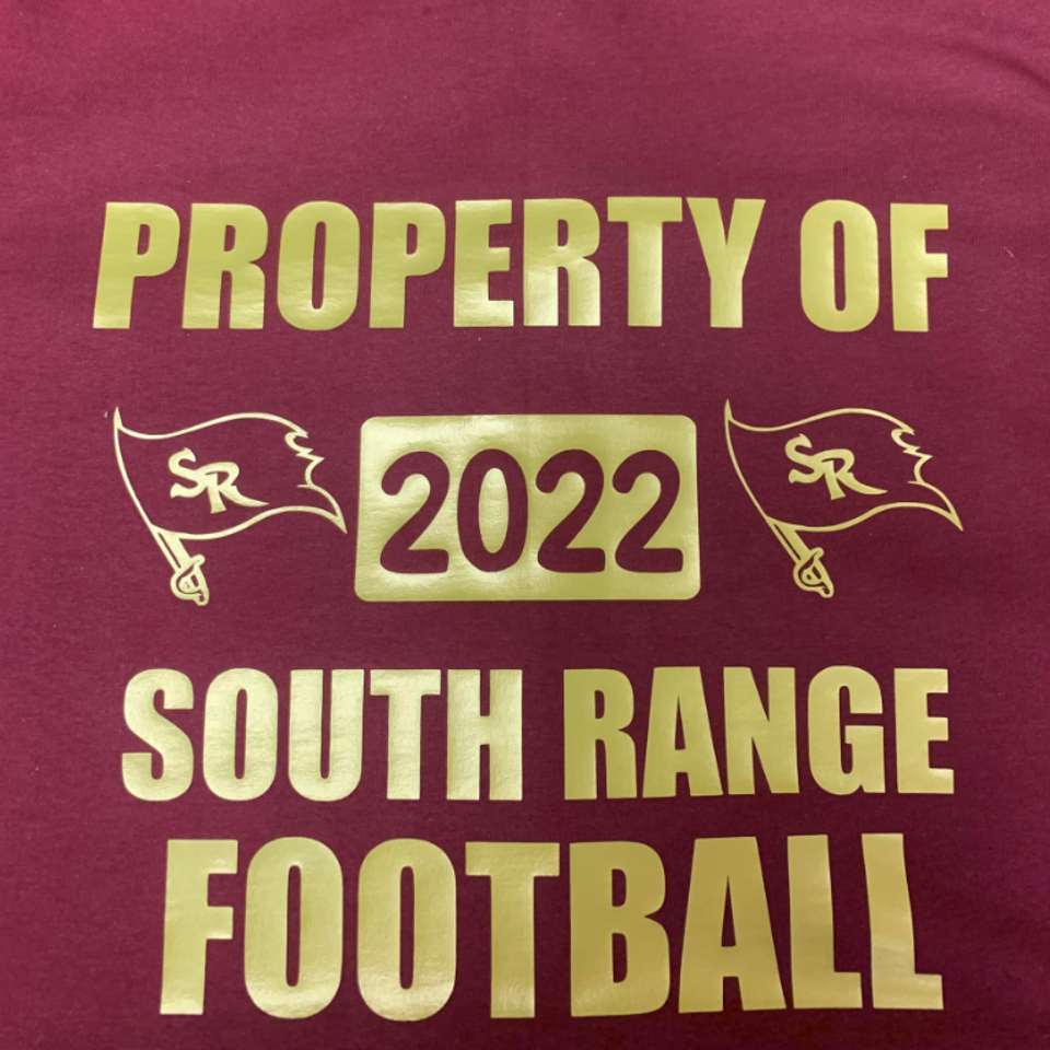 Maroon shirt with gold "Property of 2022 South Range Football" design and South Range Raiders flag graphics.
