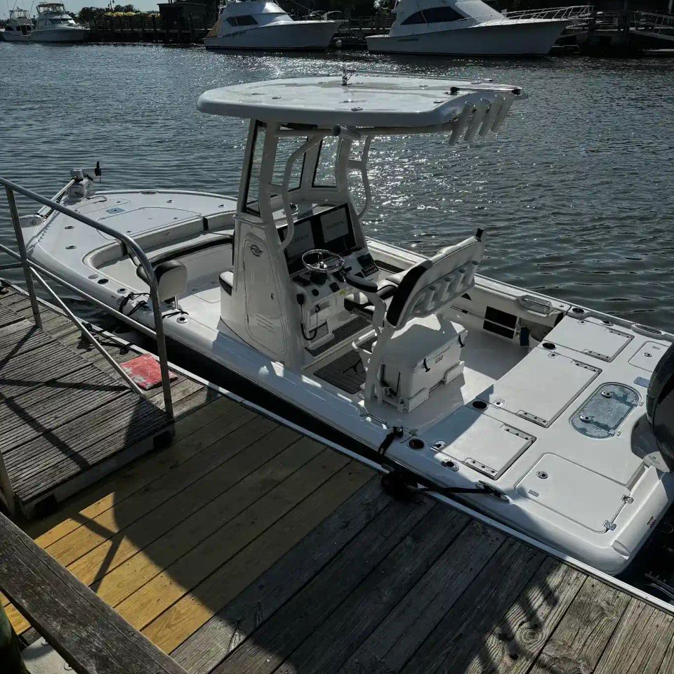 White Charleston fishing charter skiff docked at Shem Creek marina near waterfront restaurants