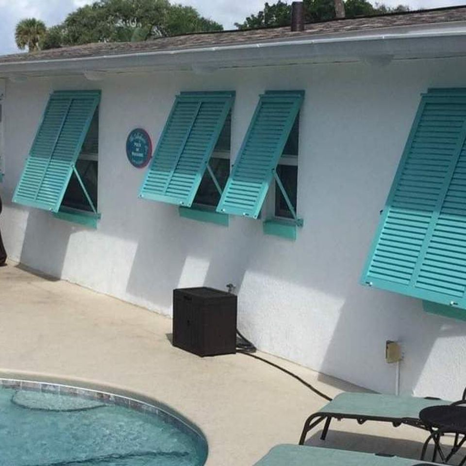 Teal bahama shutters on pool deck