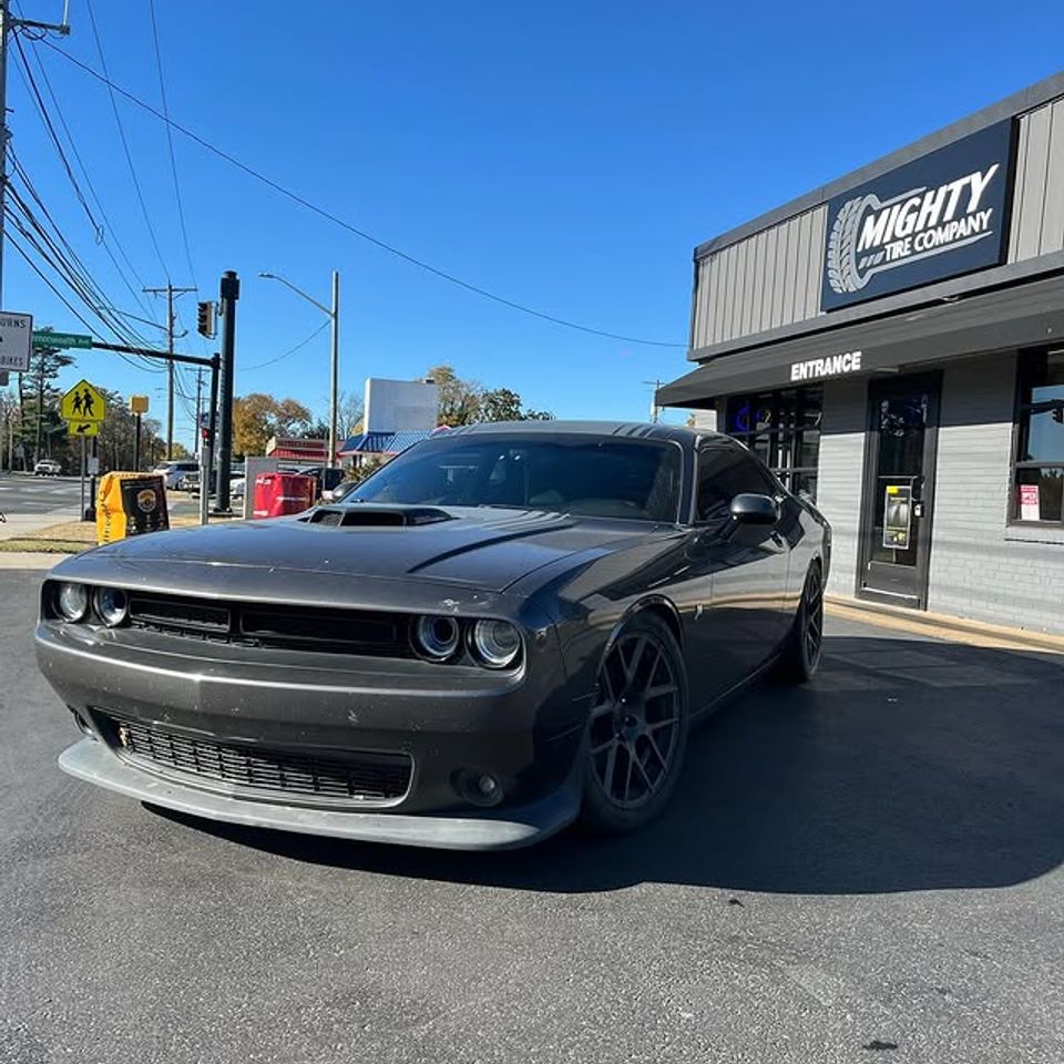 Gray Dodge Challenger with new black wheels parked outside Mighty Tire Company in Claymont DE
