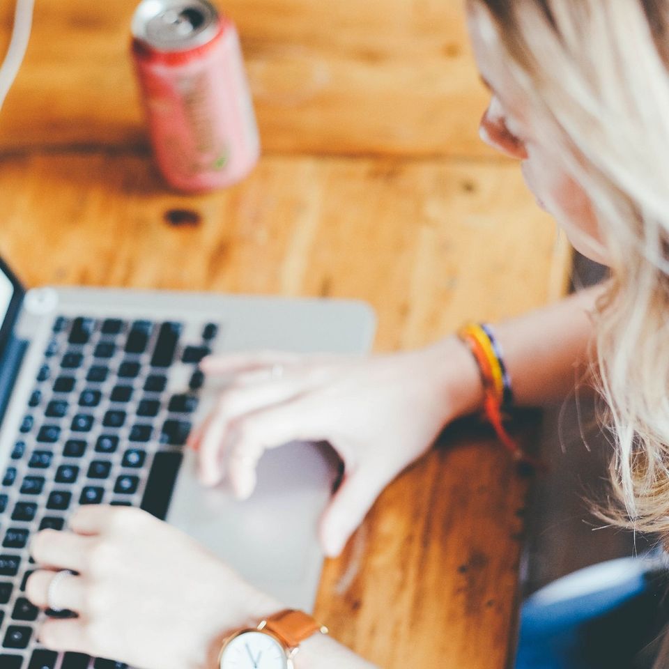 Blonde hair woman using keyboard navigation on her laptop 