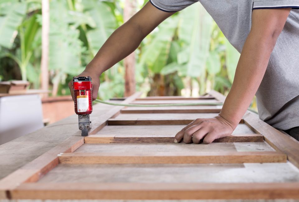 Carpenter using nail gun to build furniture during handyman services on Long Island NY