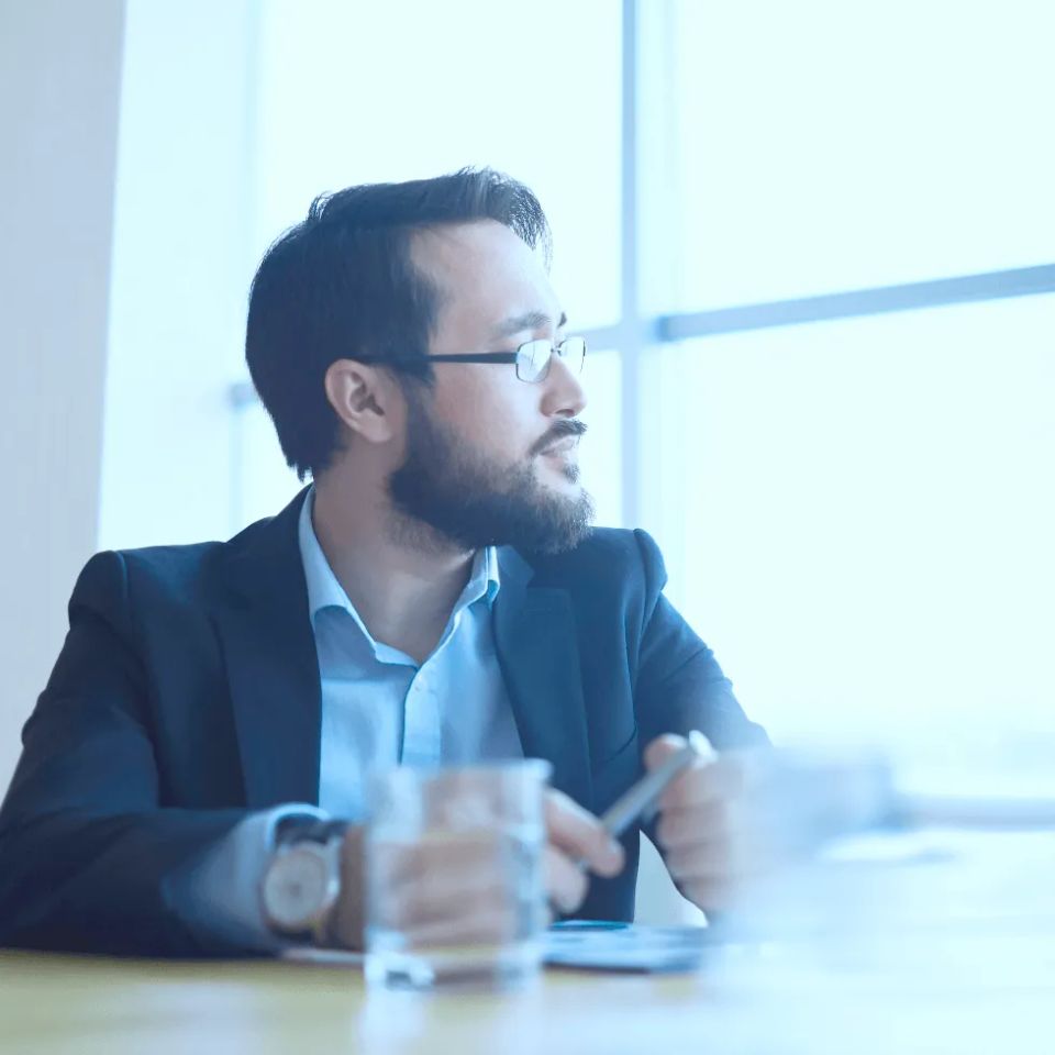 Businessman looking out window in thought