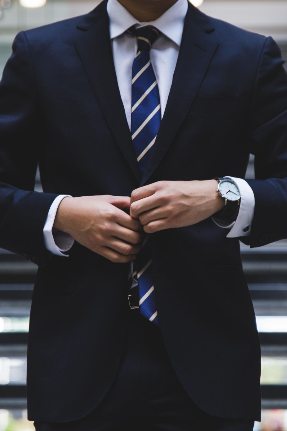 business man fixing his suit for a meeting in front of a stairway
