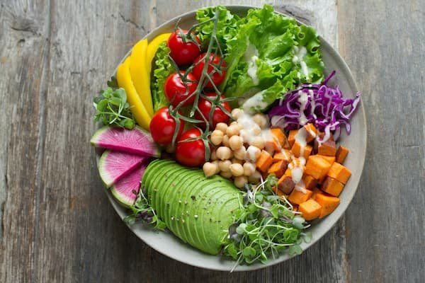 A beautiful salad bowl with 7 different colorful vegetables in it 