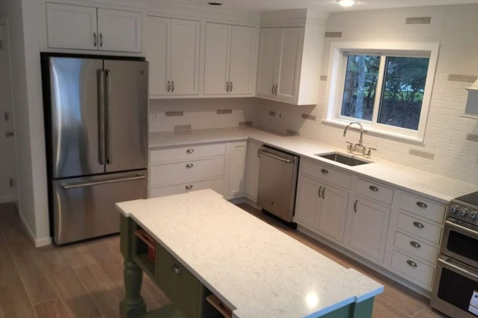 Remodeled kitchen with white cabinets and green island by general contractor in Suffolk County NY