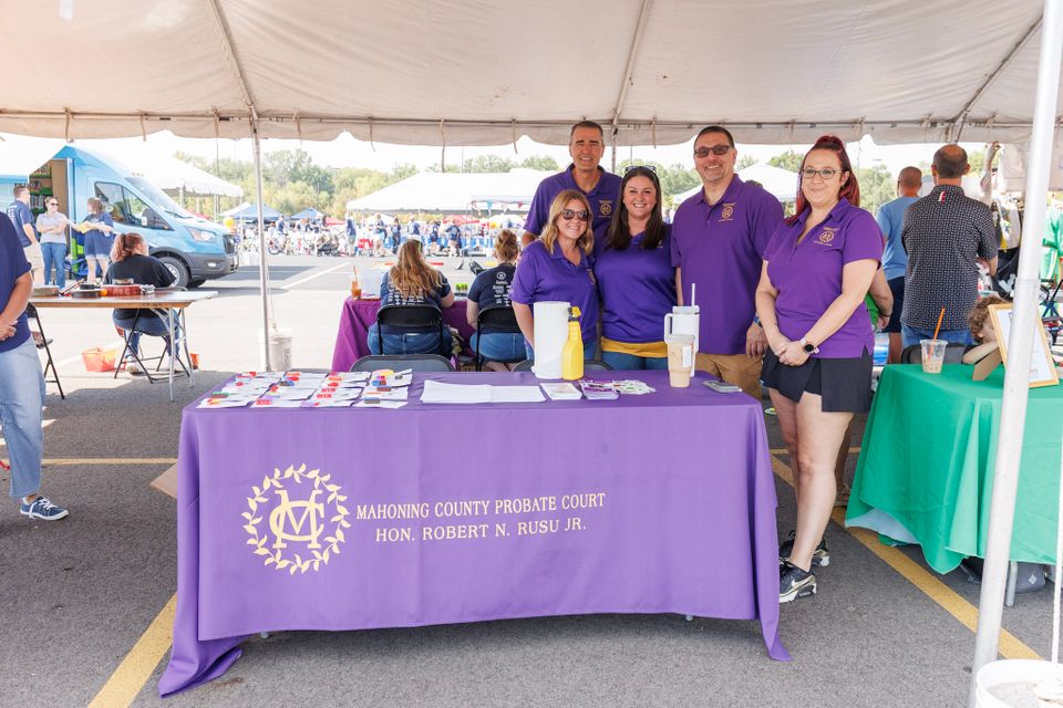 Representatives from the Mahoning County Probate Court staffing an informational booth under a tent during the DSAV Buddy Walk community event.