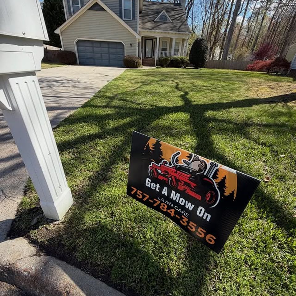 Cut grass with the Get A Mow On LLC yard sign in front