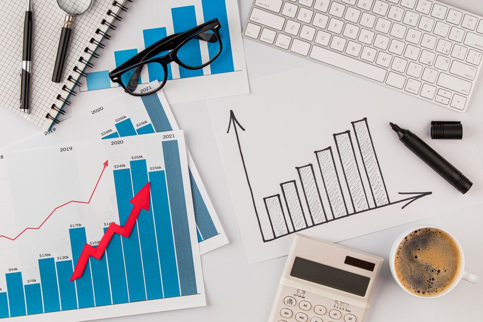 Top view office desk with growth chart glasses
