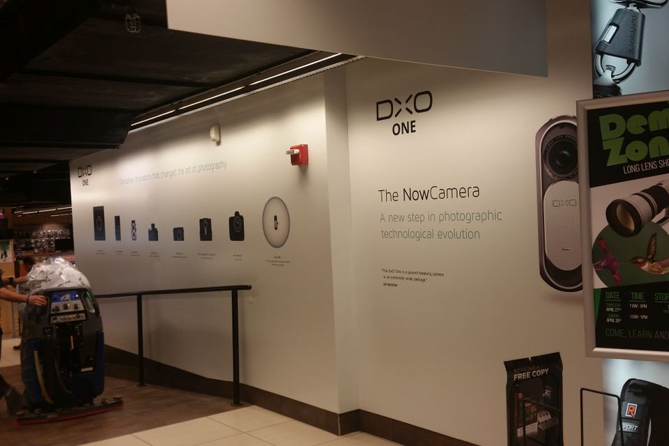 Printed wall graphics running the length of a retail interior wall with a product logo, an image timeline and a large product panel