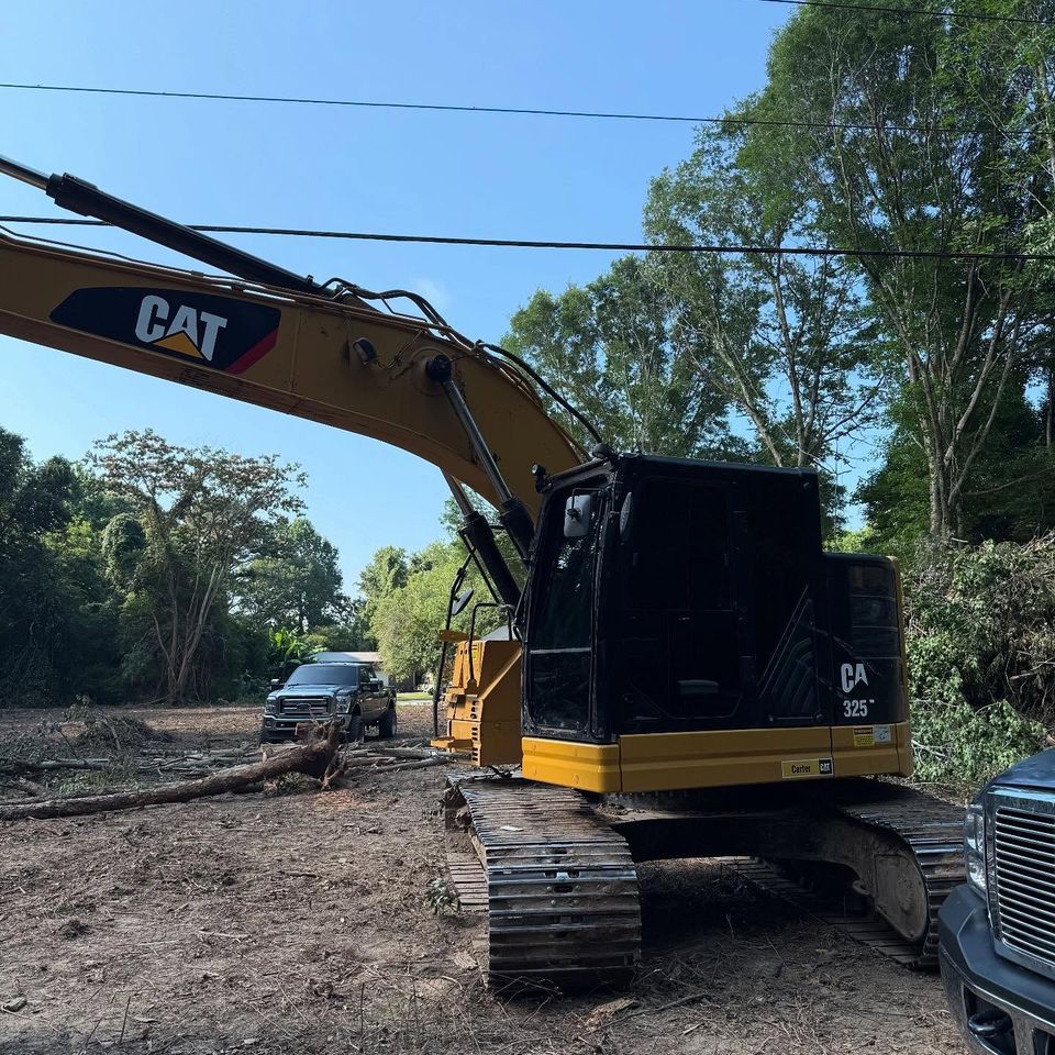 Cat 325 excavator with dark tinted cab glass on a land clearing site after heavy equipment tint in Moyock NC