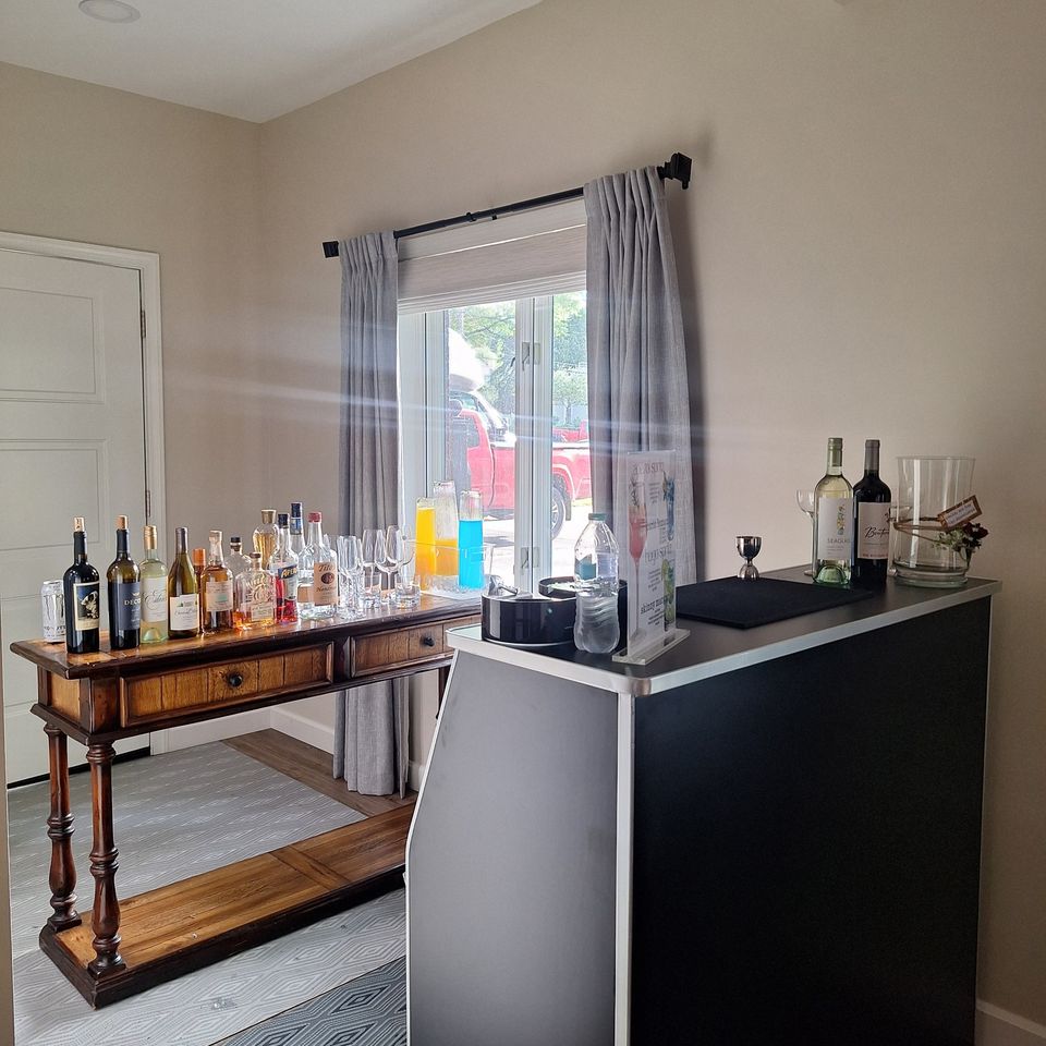 Home event full bar setup with liquor bottles, mixers, and serving station 