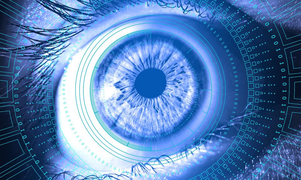 A close-up image of a blue eye surrounded by digital elements and circuits, giving a futuristic and technological appearance.