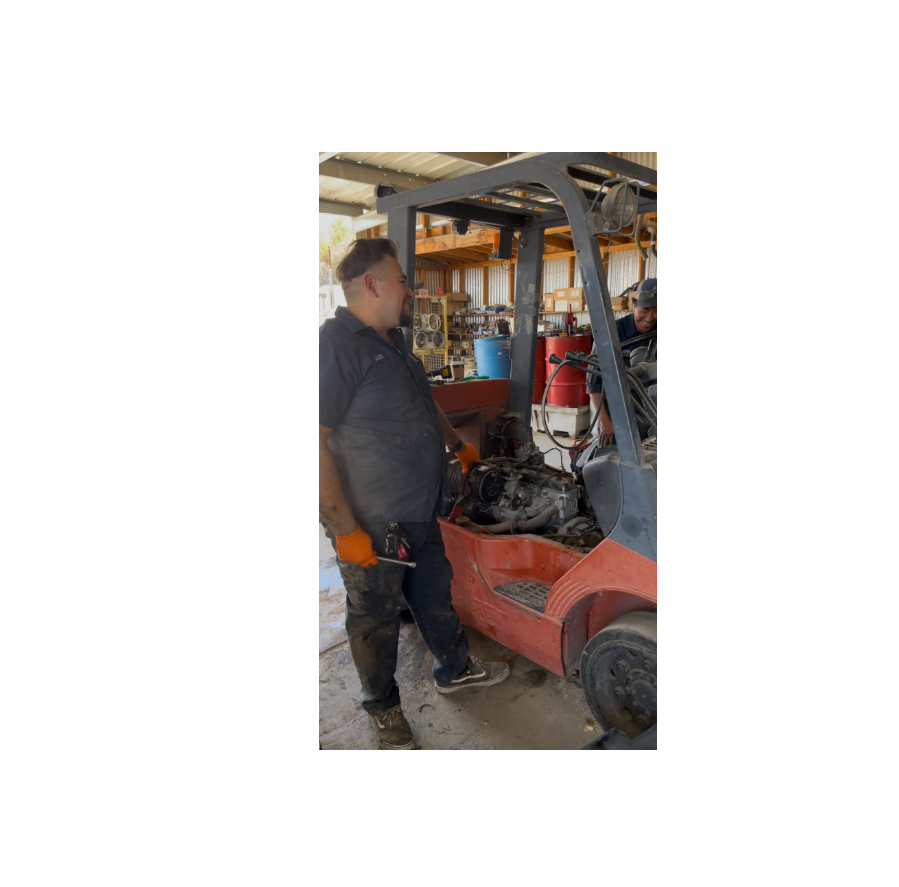 Image of 2 forklift technicians working together on the maintenance of a customer forklift