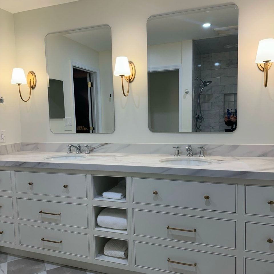 Double vanity with marble countertop, gold sconces, and checkered tile floor from a Cleveland bathroom remodel