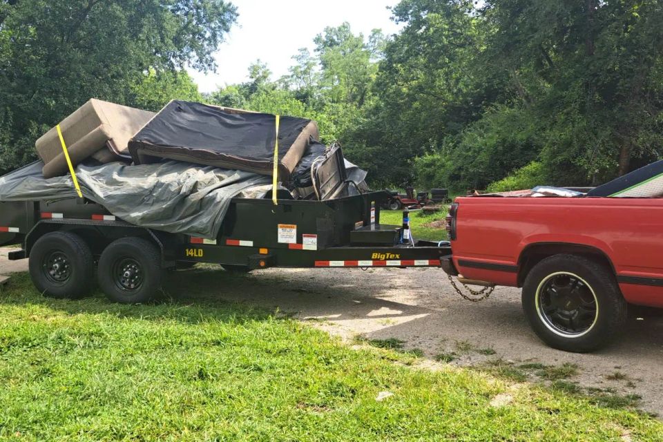 Rent-A-Man Dumpster Rentals trailer loaded with furniture and household debris.
