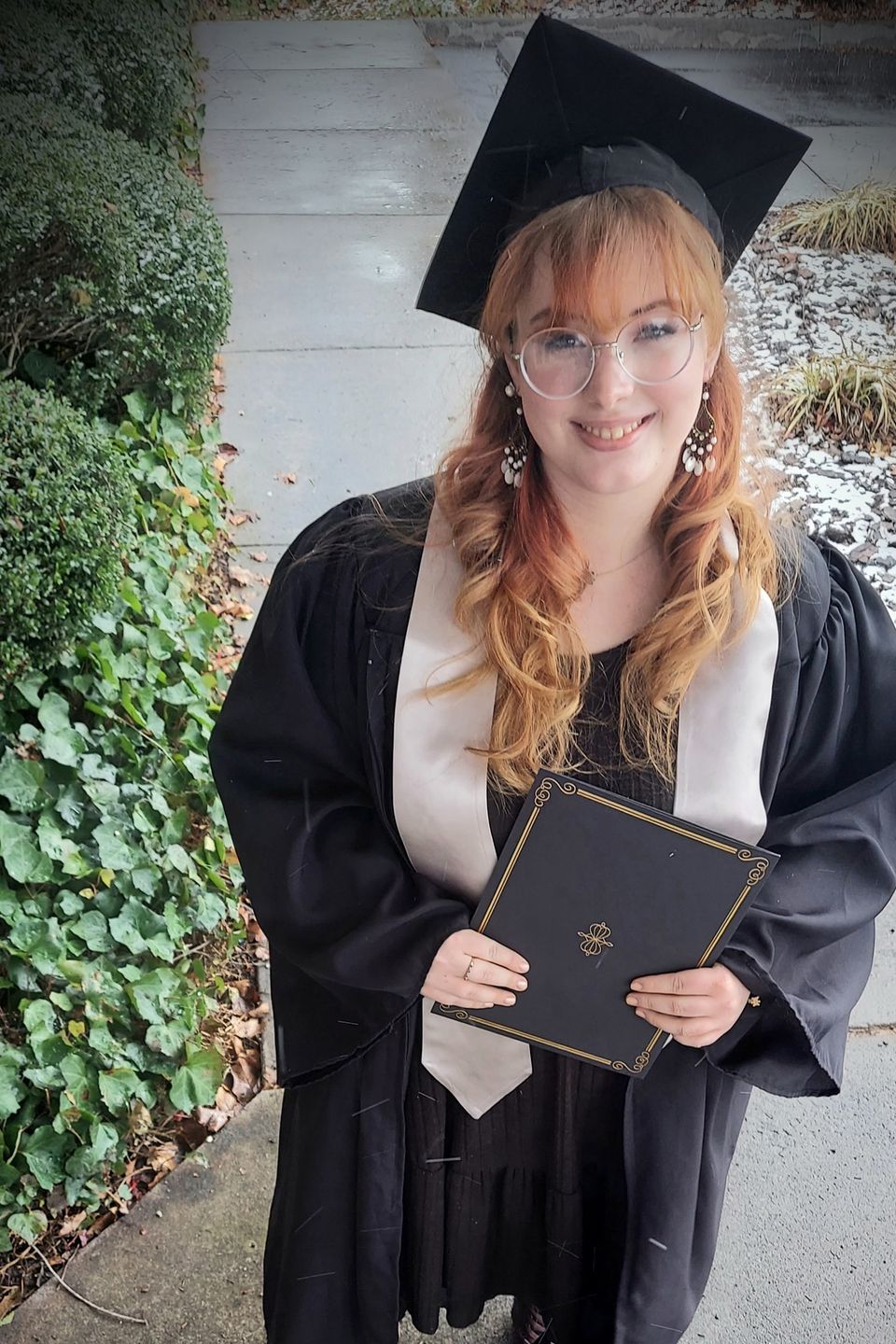 Beauty school graduate smiling with diploma after completing training