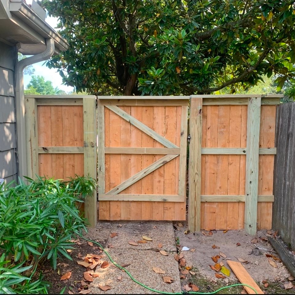 Double wood gate with cross-brace design installed beside gray home in Virginia Beach VA