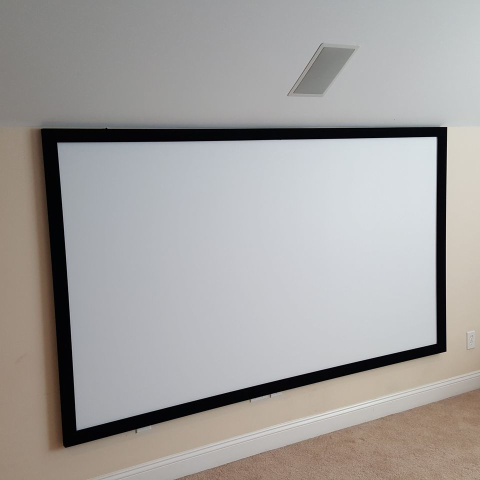 Large projector screen wall mounted in theater room in greenville sc