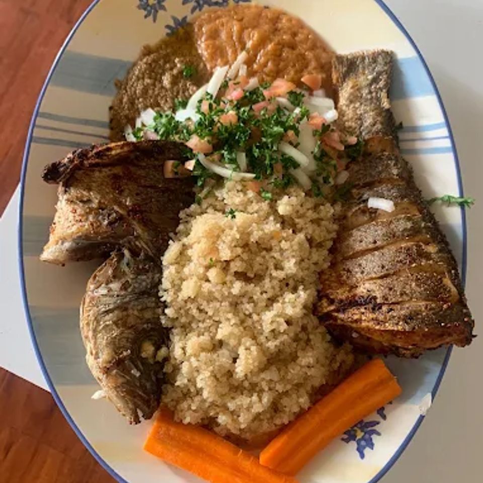 Fried whole fish platter with couscous, carrots and fresh onion tomato relish at a Cameroonian restaurant in LA