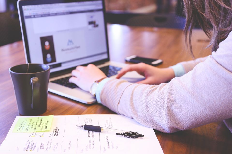 Person typing website content on computer