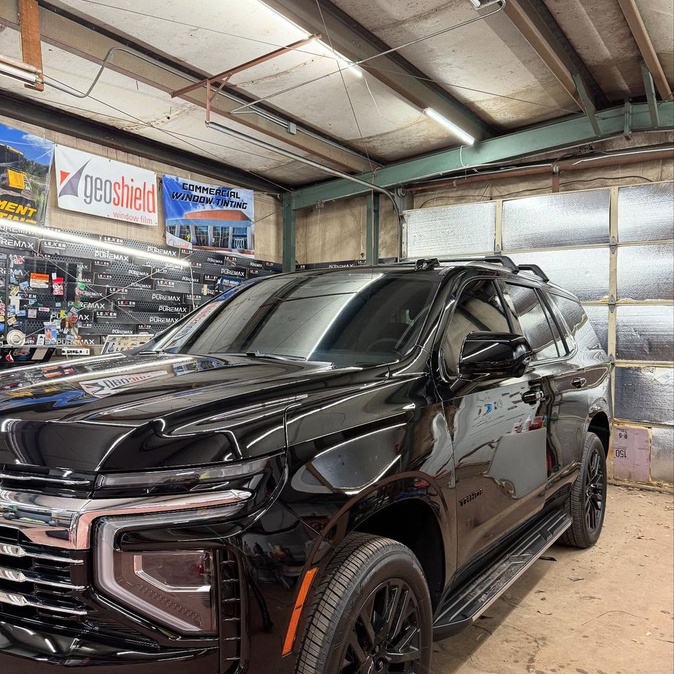 Black Chevrolet Tahoe with dark tinted windows after auto tint service in Moyock NC