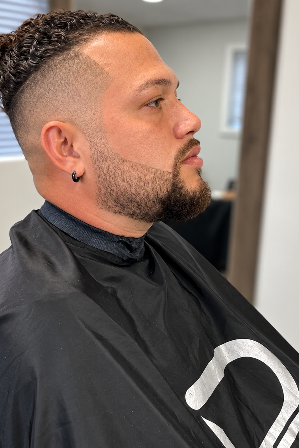 This image shows a man posing after a fresh haircut.