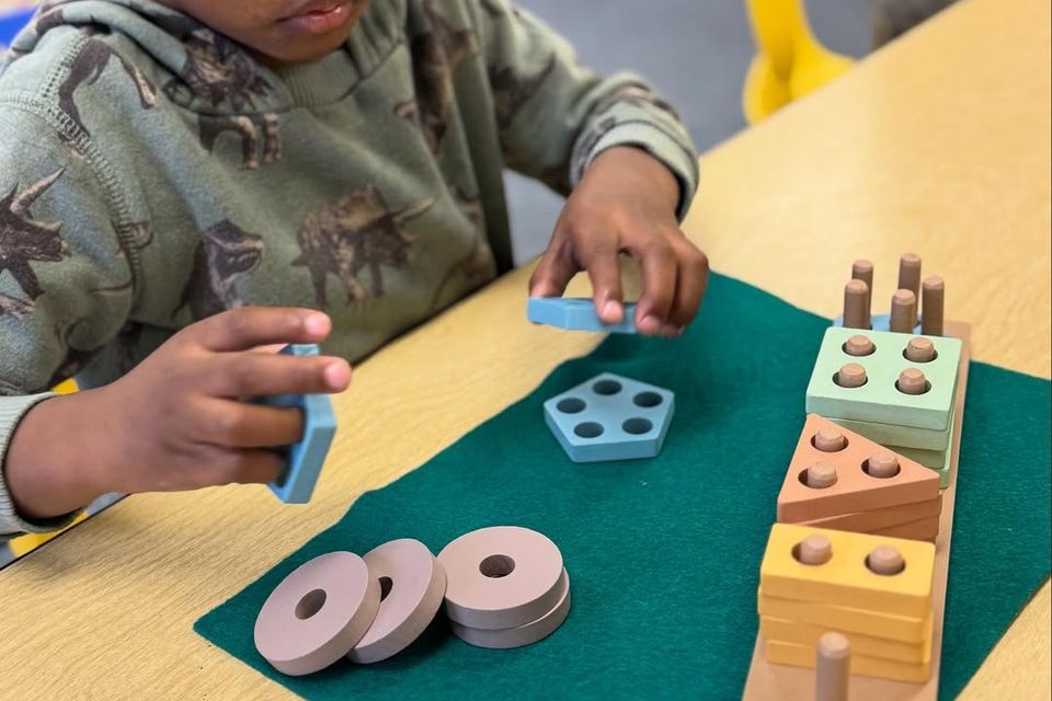 A child at Montessori Magic Key in Palmdale, CA playing with toy blocks