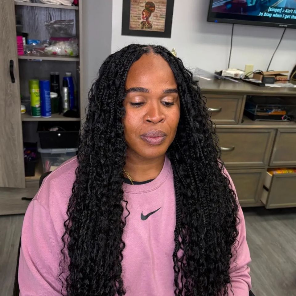 Client with long black goddess braids with wavy ends after hair braiding service in Los Angeles CA