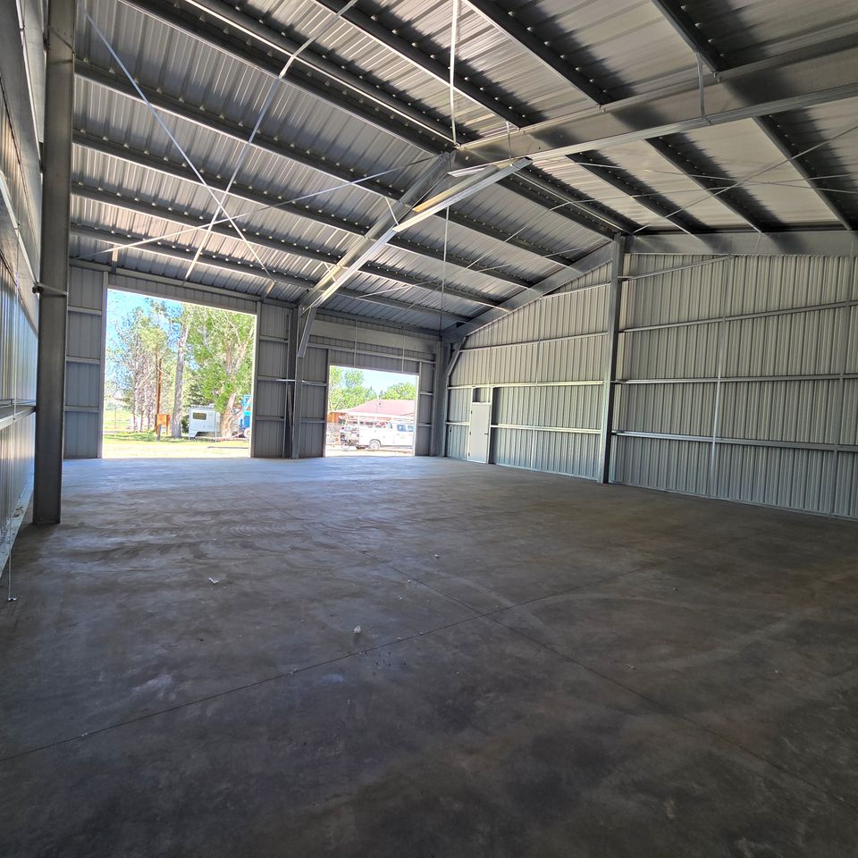 Metal shop building interior with open drive-through bay doors on a Trout Creek MT property