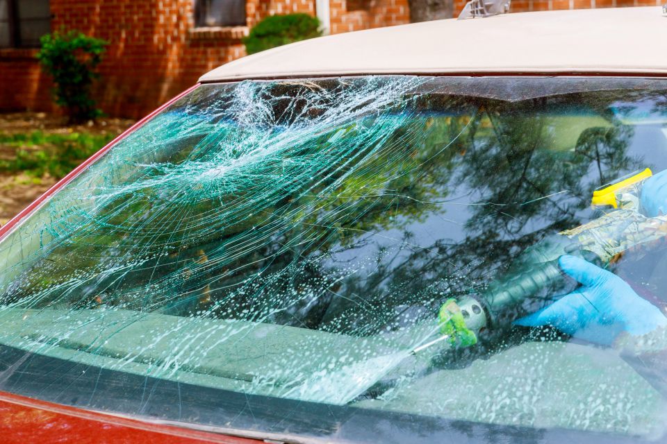 Workers remotion an automobile with a broken windscreen or windshield