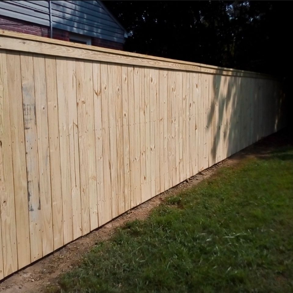 Wood privacy fence with cap rail installed along backyard property line in Virginia Beach VA