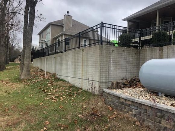 Residential iron fence on brick wall
