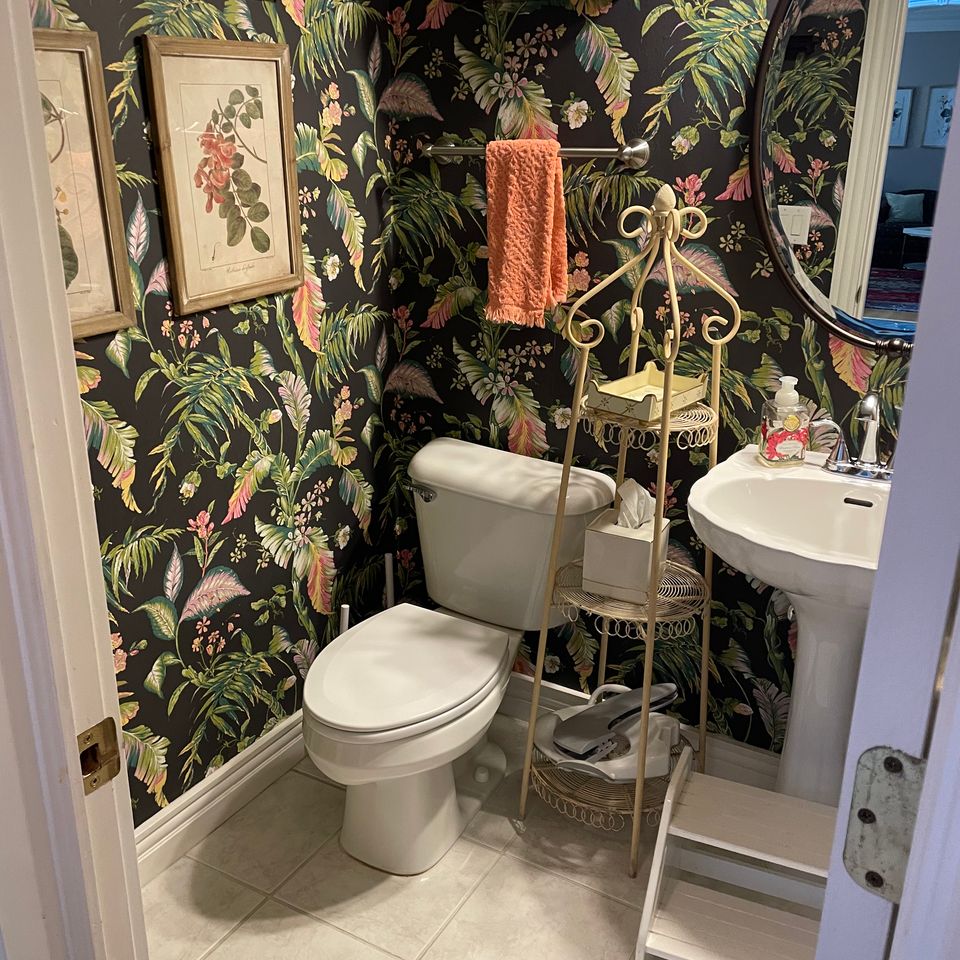 Tidy powder room with floral wallpaper and pedestal sink after a house cleaning service in Virginia Beach VA