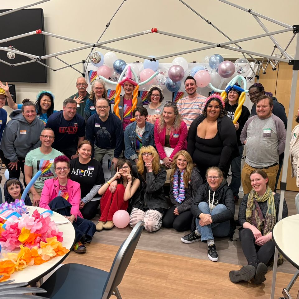 Prism event group photo. A range of people standing together and smiling