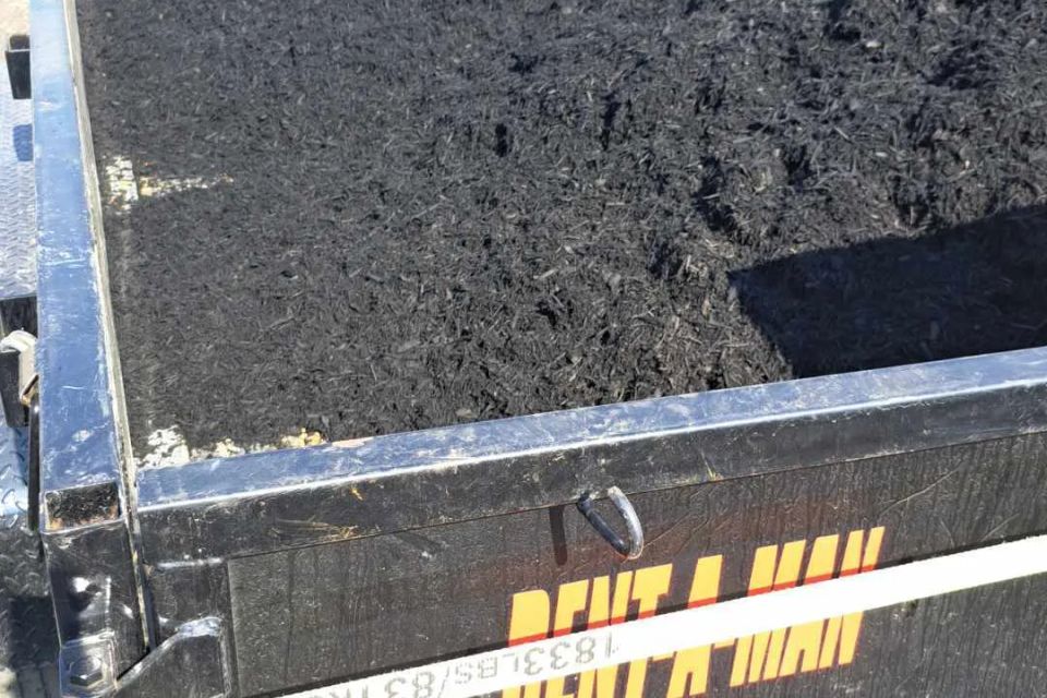Trailer filled with premium black mulch ready for landscape and mulch installation services.