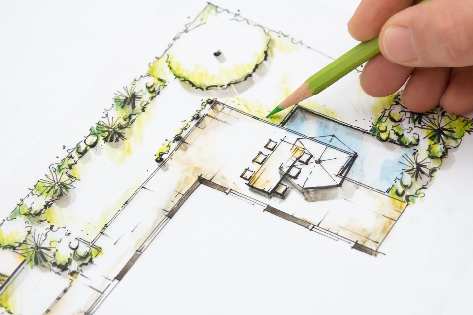 A person drawing a blueprint of a landscape design