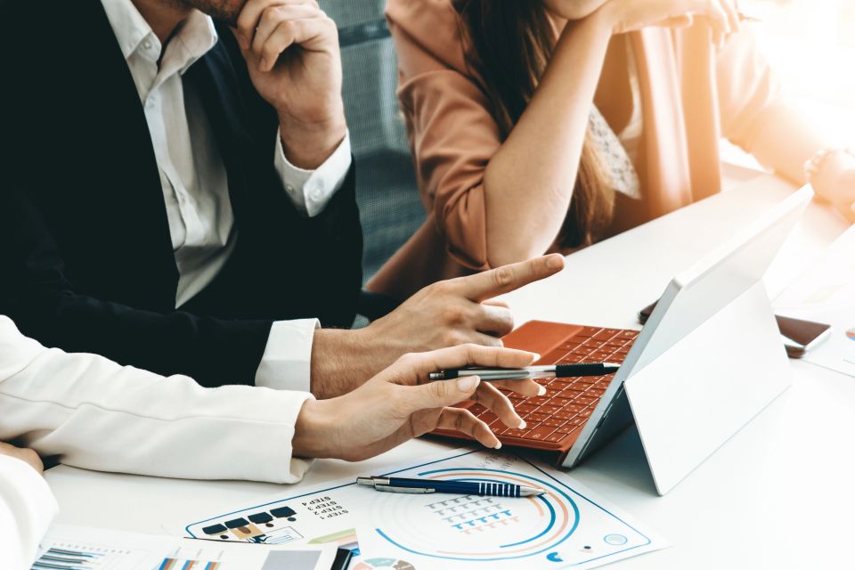 Businessman meeting taking place and looking on their laptop